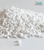 Lightweight white volcanic perlite granules mixed with dark potting soil.
